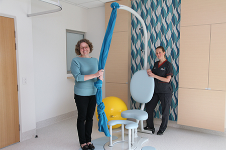 Two midwives stand beside birthing equipment in the Family Birthing Centre