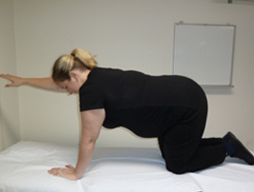 Woman on her hands and knees with her right arm pointing forward