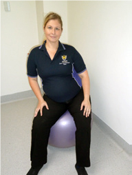 Woman sitting on a fitball circling her hips